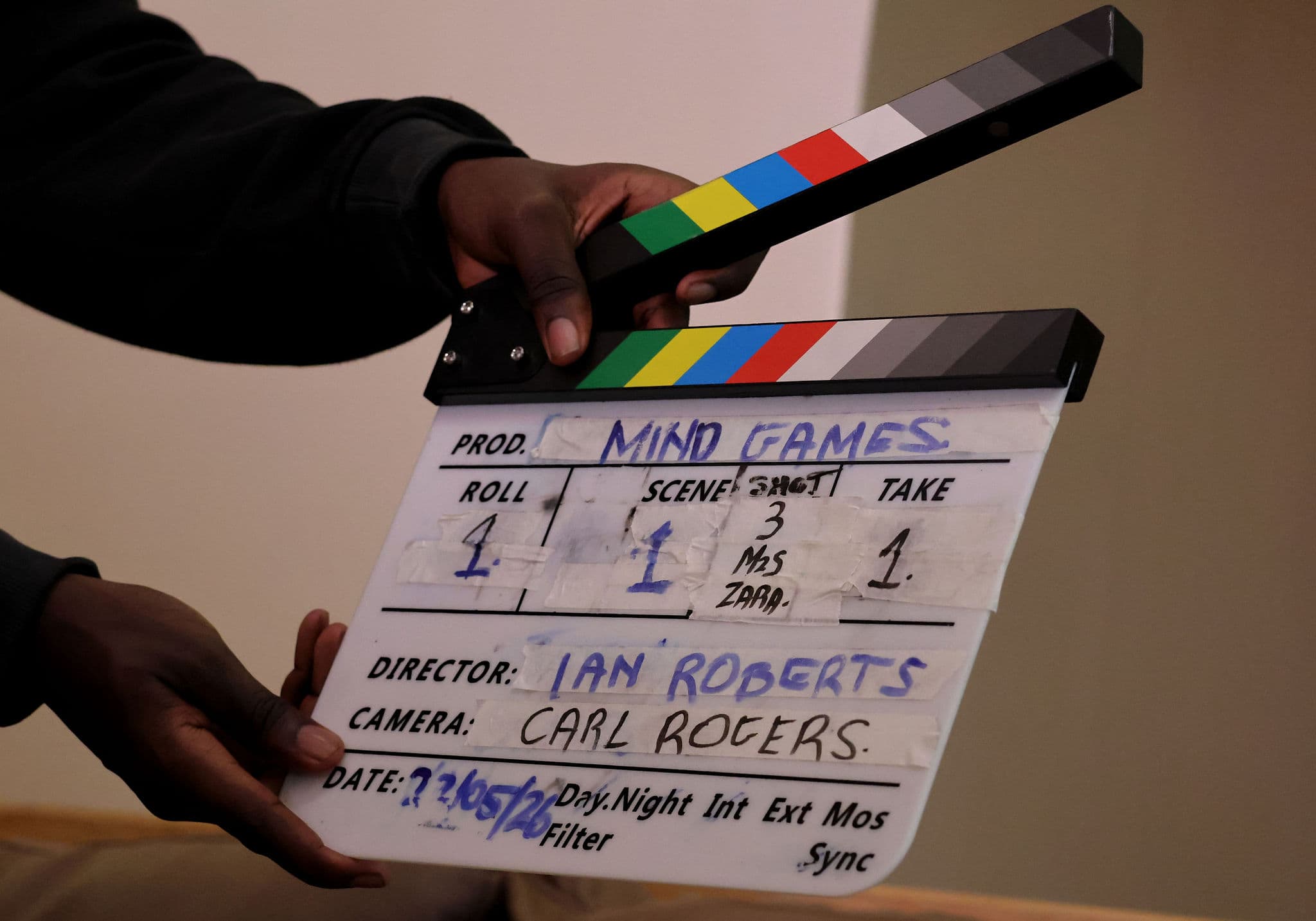 A clapperboard marked Mind Games held up on set before a take