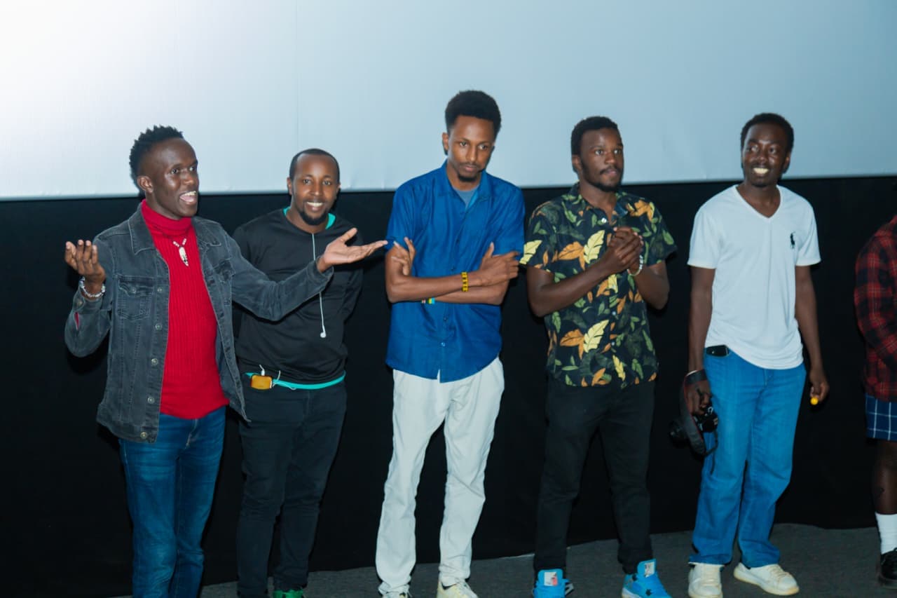 The filmmakers standing together in front of the screen after the Sauti ya Mtaa screening